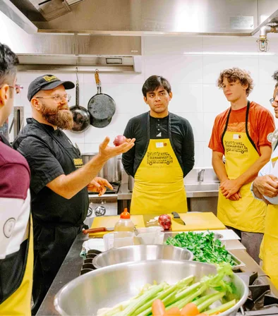 Chef giving instructions to a corporate team at an OzHarvest Cooking for a Cause session.